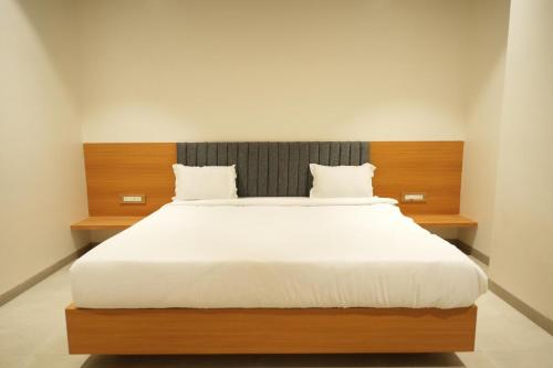 a bedroom with a large bed with a wooden headboard at Hotel Elite in Nashik
