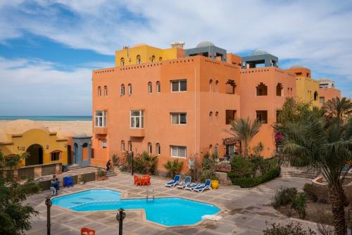 a large building with a pool in front of it at Al Dora Resort All Inclusive Hotel in Hurghada