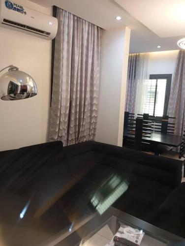 ein Wohnzimmer mit einer schwarzen Couch und einem Tisch in der Unterkunft Almadies 2 - Appt 2 chambres moderne tout confort - 200m du Rd Point Sedima in Rufisque