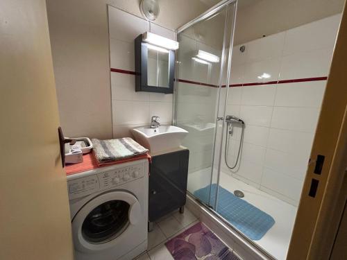 une salle de bain avec une machine à laver et un lavabo dans l'établissement Plaisir a la mer c, à Courseulles-sur-Mer