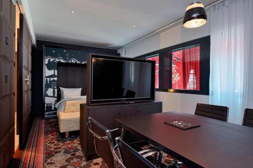 a hotel room with a television and a bedroom at Kameha Grand Zurich, Autograph Collection in Glattbrugg