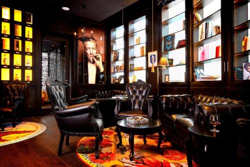 a bar with leather chairs and a couch and a table at Kameha Grand Zurich, Autograph Collection in Glattbrugg
