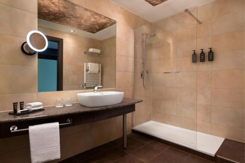 a bathroom with a sink and a shower at Sheraton Milan Malpensa Airport Hotel & Conference Centre in Ferno
