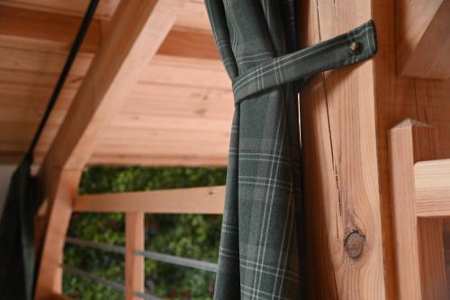 ajar door with a curtain on a wooden door at Pinéa Lodge - Chalet Authentique en Pin des Landes in Saint-Yaguen