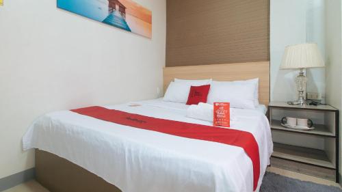 a hotel room with a bed with a red box on it at RedDoorz Hostel @ St. Paul Village LapuLapu in Mactan