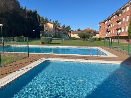 a large swimming pool in front of a building at Apartamento Verdemar in Suances