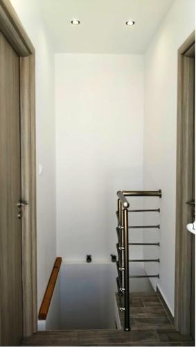 a white bathroom with a bath tub and a staircase at Angelica Residence in Gennadi
