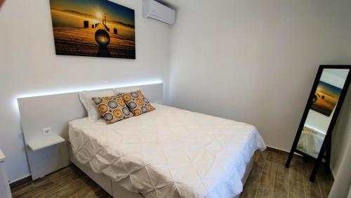 a small bedroom with a bed and a mirror at Angelica Residence in Gennadi