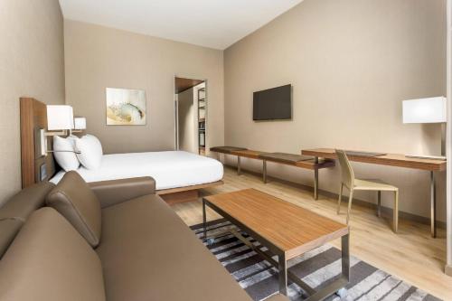 a hotel room with a bed and a couch at AC Hotel by Marriott San Francisco Airport/Oyster Point Waterfront in South San Francisco