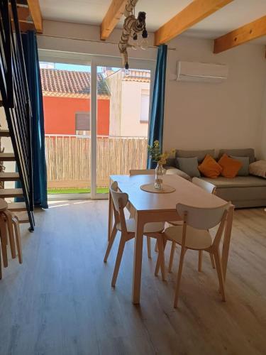 un salon avec une table, des chaises et un canapé dans l'établissement Duplex proche mer et centre, à Palavas-les-Flots