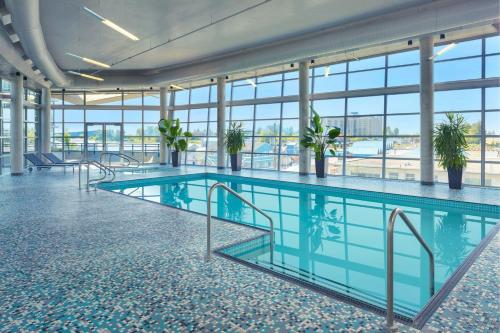 a large swimming pool in a building with windows at The Westin Wall Centre, Vancouver Airport in Richmond