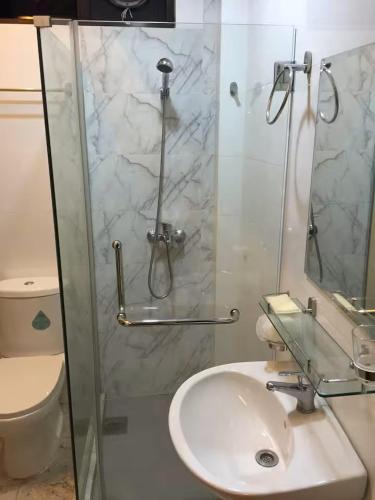 a bathroom with a sink and a glass shower at Master Room at Orchard Road in Singapore