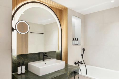 a bathroom with a sink and a mirror at Imperial Riding School, Autograph Collection in Vienna