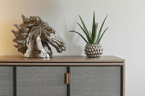 a metal horse head on a dresser with a pineapple at Imperial Riding School, Autograph Collection in Vienna