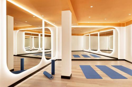 a gym with blue mats and white columns at Imperial Riding School, Autograph Collection in Vienna