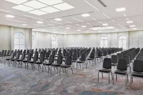 an empty room with rows of chairs in a hall at Imperial Riding School, Autograph Collection in Vienna
