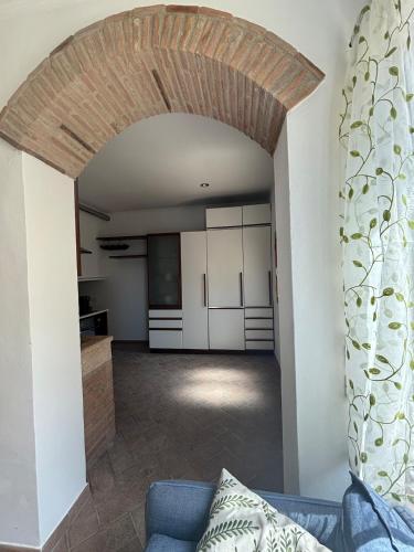 a living room with a blue couch and a kitchen at SOFT ALBA apartment in Sasso dʼOmbrone