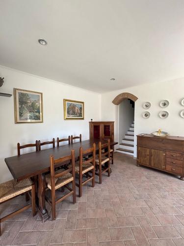 a dining room with a wooden table and benches at SOFT ALBA apartment in Sasso dʼOmbrone