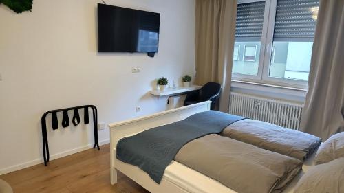 a bedroom with a bed and a tv on the wall at Katalyma in Schweinfurt