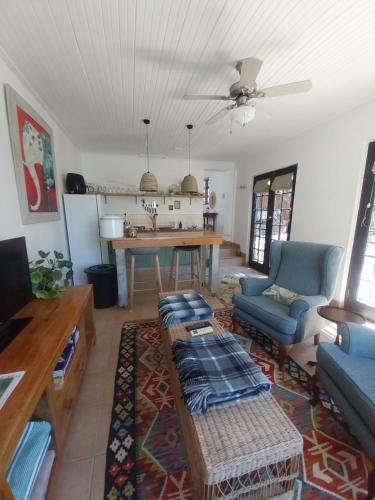 ein Wohnzimmer mit einem Tisch und einem blauen Sofa in der Unterkunft Mountain View - The Little Gem in Montagu