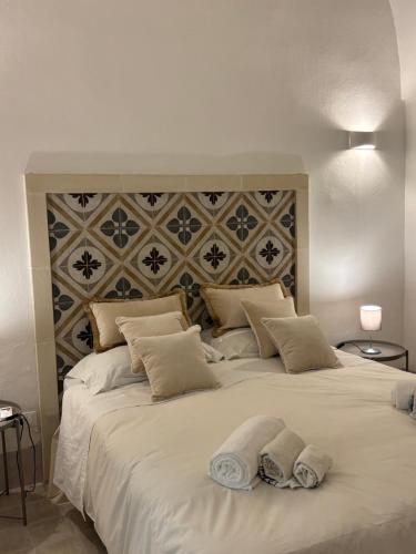 a large white bed with two towels on it at La Casetta Casa Vacanze in Alessano