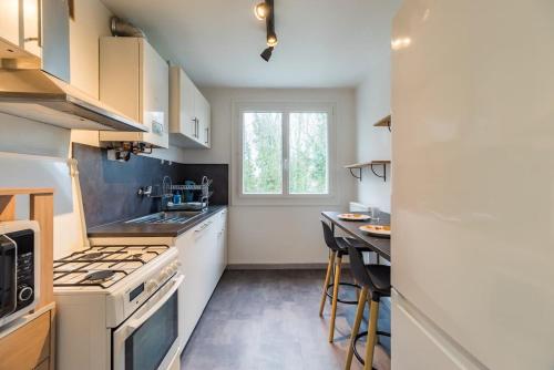 Il comprend une petite cuisine équipée d'une cuisinière et d'une table. dans l'établissement Grand appartement proche gare de Guingamp, à Guingamp