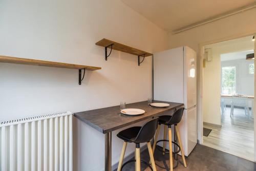 une cuisine avec une table et des tabourets dans une pièce dans l'établissement Grand appartement proche gare de Guingamp, à Guingamp