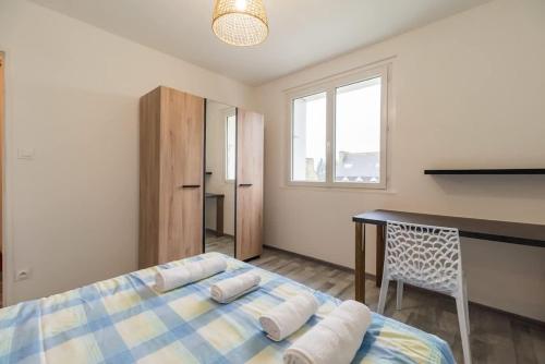 une chambre avec un lit, une table et un bureau dans l'établissement Grand appartement proche gare de Guingamp, à Guingamp