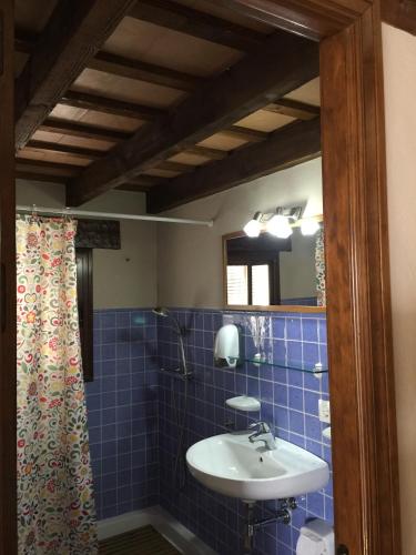 a blue tiled bathroom with a sink and a mirror at Casa Rural Aldea Chica in Los Caños de Meca