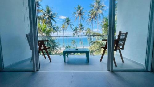 a room with a table and chairs and a view of the ocean at Villa LA Kurumba in Ambalangoda