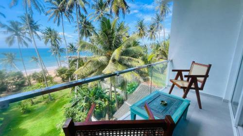 a balcony with two chairs and a view of the ocean at Villa LA Kurumba in Ambalangoda