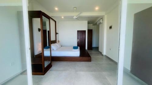 a bedroom with a bed and a mirror at Villa LA Kurumba in Ambalangoda