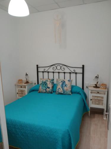 a bedroom with a blue bed with two night stands at La casita salinera in El Pozo del Cabo