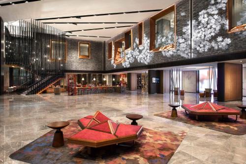 a lobby of a hotel with tables and chairs at Renaissance Xi'an Hotel in Xi'an