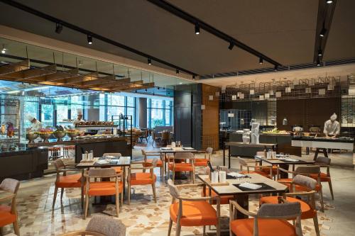 a restaurant with tables and chairs and a kitchen at Renaissance Xi'an Hotel in Xi'an