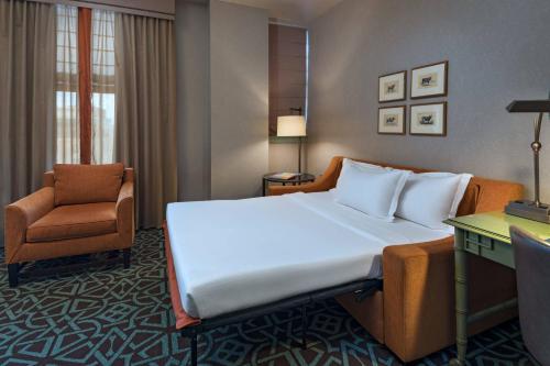 a hotel room with a large bed and a chair at Hotel ICON, Autograph Collection in Houston