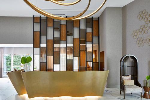 a lobby with a reception desk with a chandelier at The Del Monte Lodge Renaissance Rochester Hotel & Spa in Rochester