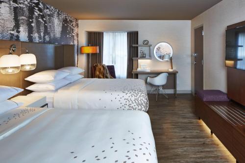 a hotel room with two beds and a desk at The Del Monte Lodge Renaissance Rochester Hotel & Spa in Rochester