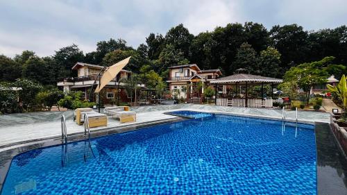 a large swimming pool in front of a house at Vanhills - Luxury Home Stay in Jim Corbett in Kota Bāgh