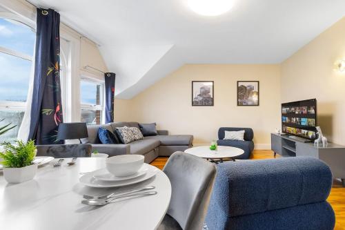 a living room with a couch and a table at Lovely 4-BR Home In Leyton - Sleeps 14, Near Tube, Arcade, 100inchTV in London