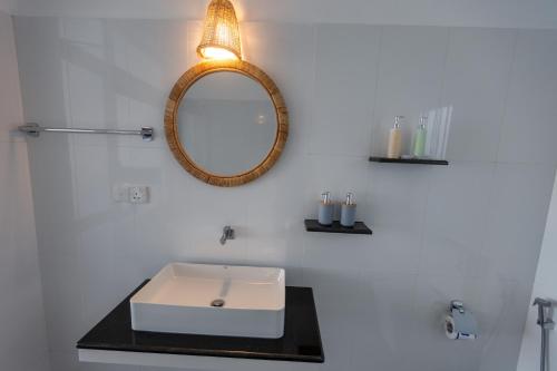 a bathroom with a sink and a mirror on the wall at Peacock Beach Hotel Unawatuna in Unawatuna