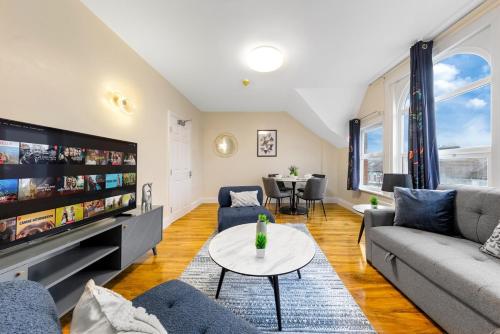 a living room with a couch and a tv at Lovely 4-BR Home In Leyton - Sleeps 14, Near Tube, Arcade, 100inchTV in London
