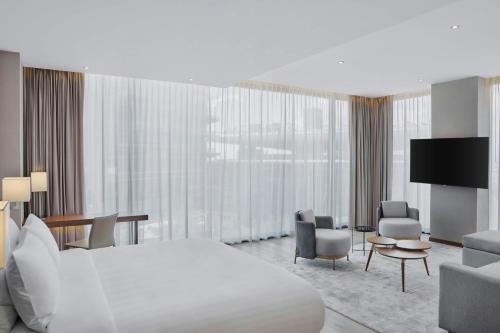 Una habitación de hotel con una cama, un escritorio y sillas. en AC Hotel by Marriott Saltillo, en Saltillo