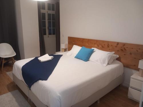 a bedroom with a large bed with blue and white pillows at Lagoa Hostel & Suites in Lagoa