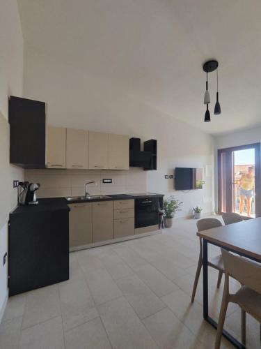 a large kitchen with a table and a dining room at Ale house experience in Riola Sardo