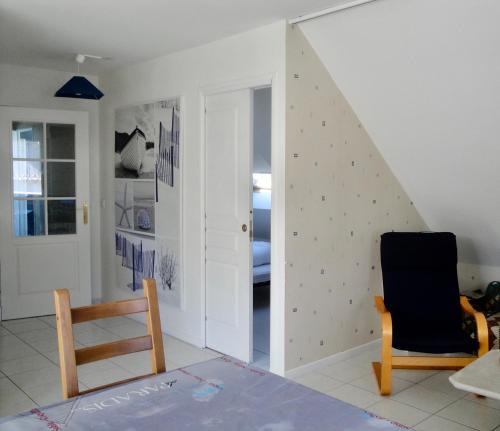 Cette chambre est dotée d'un mur avec une porte et une chaise. dans l'établissement Relax à Carnac, à Carnac