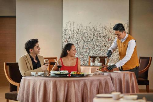 a group of people sitting around a table eating food at Renaissance Johor Bahru Hotel in Johor Bahru