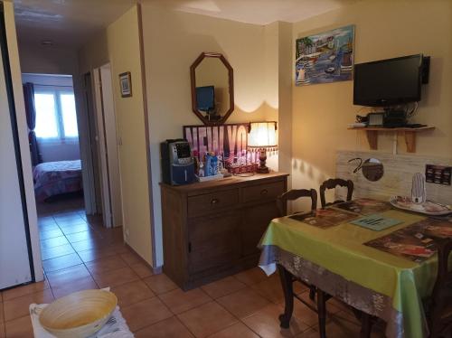 une salle à manger avec une table et un miroir dans l'établissement Plaisir a la mer B, à Bernières-sur-Mer