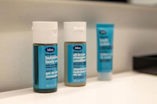 a couple of bottles of hair products sitting on a counter at Aloft St. Louis Cortex in Saint Louis