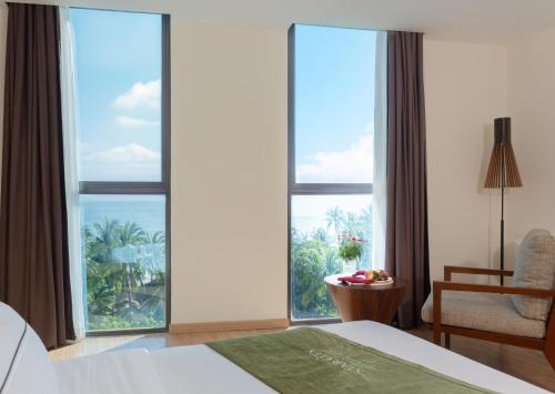 a hotel room with a bed and a large window at Starcity Bayfront Nha Trang Hotel in Nha Trang